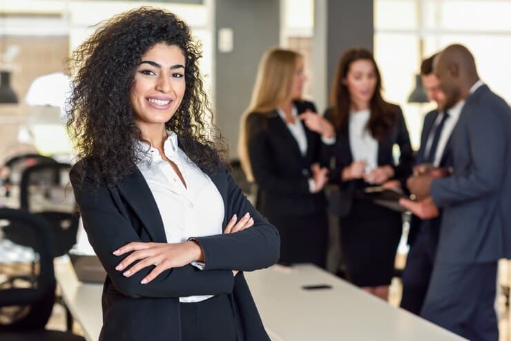 Businesswoman leader standing with a team in a modern office