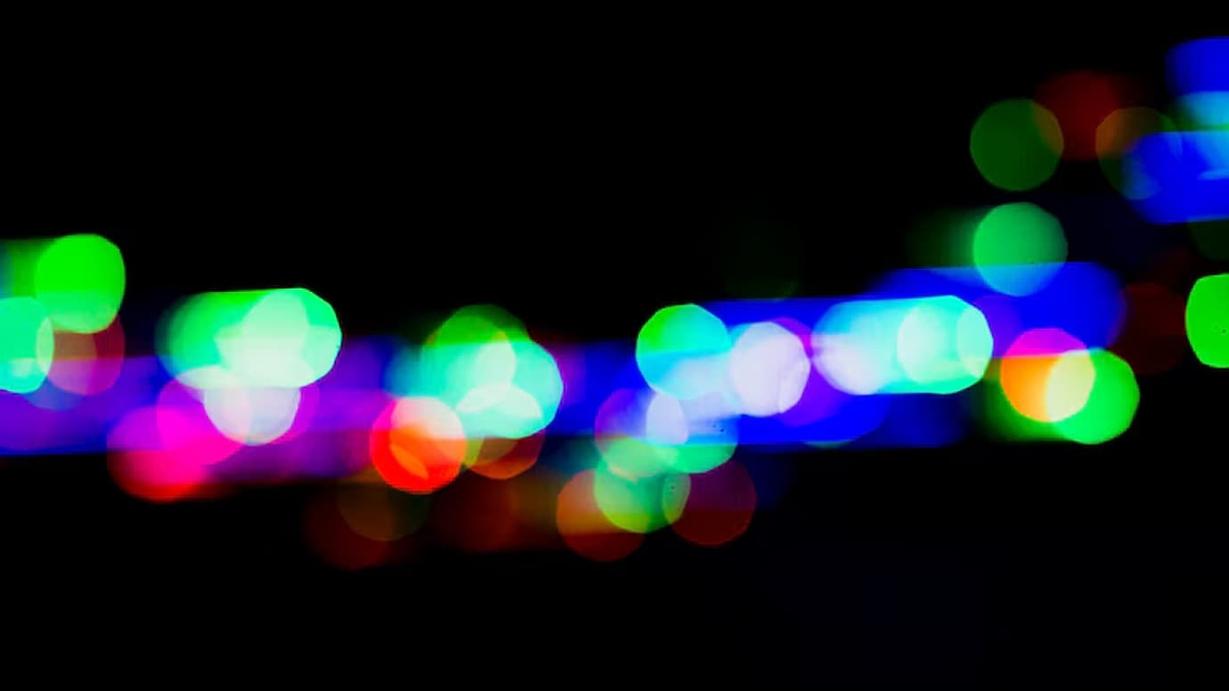 Colorful bokeh lights glowing in a quiet dark rhythm